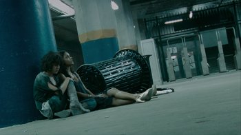 Movie still from “Cloverfield” (2008), directed by Matt Reeves – Two people sitting next to each other on the ground; Wide shot, Low angle