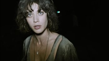 Movie still from “Cloverfield” (2008), directed by Matt Reeves – A person with short hair wearing a necklace; Close Up shot, Low angle