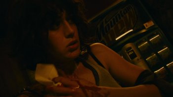 Movie still from “Cloverfield” (2008), directed by Matt Reeves – A woman sitting in front of a wall eating a piece of pizza; Close Up shot, High angle