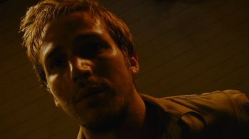 Movie still from “Cloverfield” (2008), directed by Matt Reeves – A man's face in a dark room; Close Up shot, Low angle