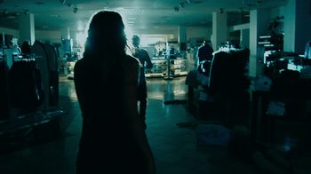 Movie still from “Cloverfield” (2008), directed by Matt Reeves – A woman standing in a room next to other people; Wide shot, Over the shoulder angle