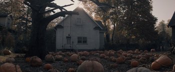 Movie still from “Cobweb” (2023), directed by Samuel Bodin – A lot of pumpkins in front of a house; Extreme Wide shot, High angle