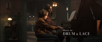 Movie still from “Cobweb” (2023), directed by Samuel Bodin – A woman and a child playing a piano; Medium shot, Overhead angle