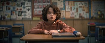 Movie still from “Cobweb” (2023), directed by Samuel Bodin – A boy sitting at a table in front of a book; Close Up shot, Low angle