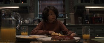 Movie still from “Cobweb” (2023), directed by Samuel Bodin – A boy sitting at a table with a plate in front of him; Medium shot, Over the shoulder angle