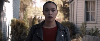 Movie still from “Cobweb” (2023), directed by Samuel Bodin – A woman in a red shirt and a leather jacket; Close Up shot, Over the shoulder angle