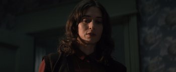 Movie still from “Cobweb” (2023), directed by Samuel Bodin – A woman with long dark hair wearing a red shirt; Close Up shot, Low angle