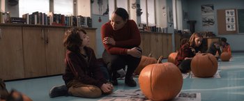 Movie still from “Cobweb” (2023), directed by Samuel Bodin – A woman and a boy sitting on the ground next to a pumpkin; Medium shot, Over the shoulder angle