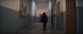 Movie still from “Cobweb” (2023), directed by Samuel Bodin – A person walking down a hallway in a building; Wide shot, Low angle