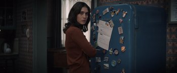 Movie still from “Cobweb” (2023), directed by Samuel Bodin – A woman standing in front of a refrigerator with magnets on it; Close Up shot, Over the shoulder angle