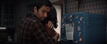 Movie still from “Cobweb” (2023), directed by Samuel Bodin – A man and a woman hugging in front of a refrigerator; Medium shot, Over the shoulder angle