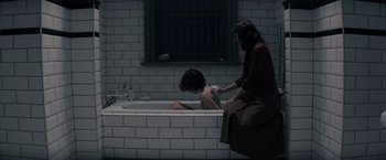 Movie still from “Cobweb” (2023), directed by Samuel Bodin – A woman sitting in a bath tub next to another woman; Medium shot, High angle