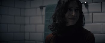 Movie still from “Cobweb” (2023), directed by Samuel Bodin – A woman with long dark hair standing next to a wall; Close Up shot, Over the shoulder angle