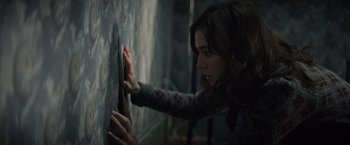 Movie still from “Cobweb” (2023), directed by Samuel Bodin – A woman leaning against a wall with her hand on the wall; Close Up shot, High angle