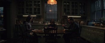 Movie still from “Cobweb” (2023), directed by Samuel Bodin – A group of people sitting at a table in a room; Wide shot, High angle