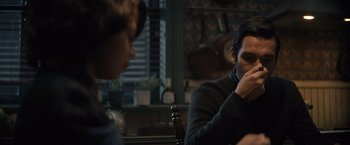 Movie still from “Cobweb” (2023), directed by Samuel Bodin – A man sitting at a table with a woman; Medium shot, Over the shoulder angle