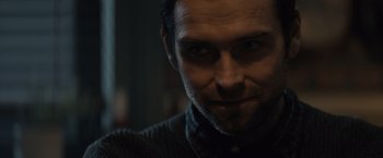 Movie still from “Cobweb” (2023), directed by Samuel Bodin – A man's face in a dimly - lit room; Close Up shot, Over the shoulder angle