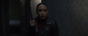 Movie still from “Cobweb” (2023), directed by Samuel Bodin – A woman in a black leather jacket holding a black cane; Close Up shot, Over the shoulder angle