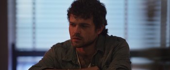 Movie still from “Cocaine Bear” (2023), directed by Elizabeth Banks – A person wearing a shirt; Close Up shot, High angle