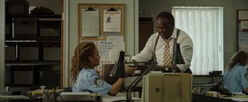Movie still from “Cocaine Bear” (2023), directed by Elizabeth Banks – A police officer sitting at a desk with a man; Medium shot, Over the shoulder angle