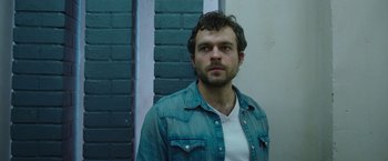 Movie still from “Cocaine Bear” (2023), directed by Elizabeth Banks – A person wearing a jean shirt; Close Up shot, Low angle