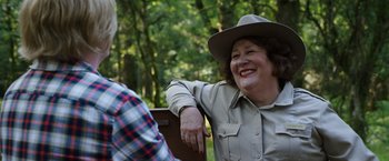 Movie still from “Cocaine Bear” (2023), directed by Elizabeth Banks – An older woman sitting on a park bench with an older man; Close Up shot, Over the shoulder angle
