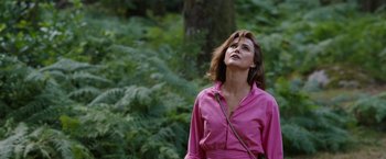 Movie still from “Cocaine Bear” (2023), directed by Elizabeth Banks – A woman in a pink shirt looking up at the sky; Medium shot, Low angle