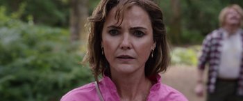Movie still from “Cocaine Bear” (2023), directed by Elizabeth Banks – A person wearing a pink shirt; Close Up shot, Over the shoulder angle