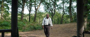 Movie still from “Cocaine Bear” (2023), directed by Elizabeth Banks – A man walking in the woods with a camera; Wide shot, Low angle