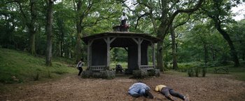 Movie still from “Cocaine Bear” (2023), directed by Elizabeth Banks – A gazebo with people laying on the ground; Extreme Wide shot, Low angle