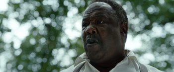 Movie still from “Cocaine Bear” (2023), directed by Elizabeth Banks – An older man is looking at the camera; Close Up shot, Low angle
