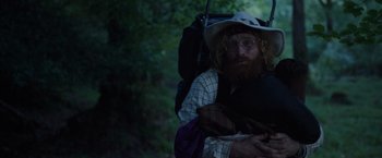 Movie still from “Cocaine Bear” (2023), directed by Elizabeth Banks – A man with a beard and a hat is holding a backpack; Medium shot, Over the shoulder angle