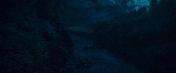 Movie still from “Cocaine Bear” (2023), directed by Elizabeth Banks – A dark night with a lot of light coming through the clouds; Extreme Wide shot, High angle