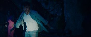 Movie still from “Cocaine Bear” (2023), directed by Elizabeth Banks – A man standing in front of a rock wall; Medium shot, Low angle