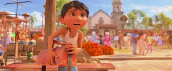 Movie still from “Coco” (2017), directed by Adrian Molina – An animated boy holding a knife in a park; Medium shot, Low angle