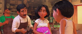 Movie still from “Coco” (2017), directed by Adrian Molina – A woman is standing next to a man and another man; Medium shot, Over the shoulder angle