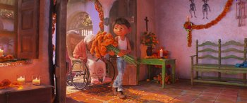 Movie still from “Coco” (2017), directed by Adrian Molina – An animated picture of a boy holding a bunch of flowers; Wide shot, Over the shoulder angle