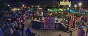 Movie still from “Coco” (2017), directed by Adrian Molina – A man is performing on a stage in a park; Wide shot, Over the shoulder angle