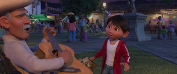 Movie still from “Coco” (2017), directed by Adrian Molina – A person is playing a guitar in front of a crowd; Medium shot, Over the shoulder angle