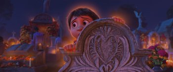 Movie still from “Coco” (2017), directed by Adrian Molina – A child peeking over the back of a chair; Medium shot, Over the shoulder angle
