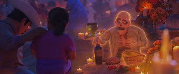 Movie still from “Coco” (2017), directed by Adrian Molina – A person with a skeleton costume sitting at a table with candles; Medium shot, Over the shoulder angle