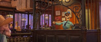 Movie still from “Coco” (2017), directed by Adrian Molina – A person is standing behind a bar in a restaurant; Wide shot, Over the shoulder angle