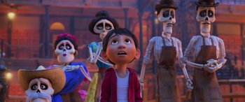 Movie still from “Coco” (2017), directed by Adrian Molina – A group of people standing next to each other in a room; Medium shot, Over the shoulder angle