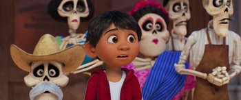 Movie still from “Coco” (2017), directed by Adrian Molina – A young boy is standing in front of a group of skeletons; Close Up shot, Over the shoulder angle