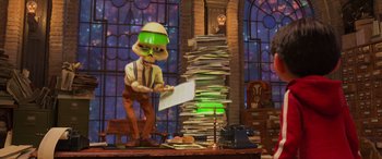 Movie still from “Coco” (2017), directed by Adrian Molina – A man in a green hat and a green hat is holding a paper; Medium shot, Low angle