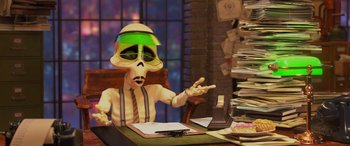 Movie still from “Coco” (2017), directed by Adrian Molina – A person sitting at a desk wearing a hat; Medium shot, Over the shoulder angle