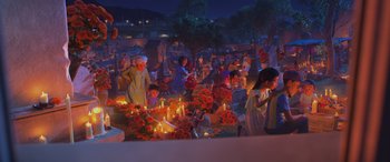 Movie still from “Coco” (2017), directed by Adrian Molina – A group of people standing around a grave with candles lit; Wide shot, High angle