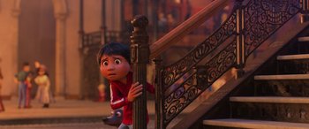 Movie still from “Coco” (2017), directed by Adrian Molina – A young boy leaning up against a railing; Wide shot, Low angle