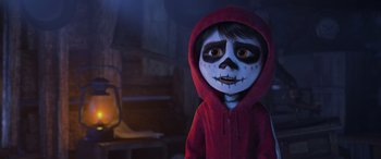 Movie still from “Coco” (2017), directed by Adrian Molina – A child dressed up as a calavera with a red hooded jacket; Medium shot, Over the shoulder angle
