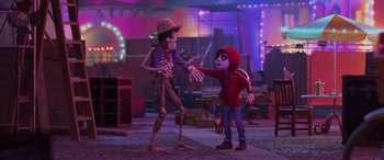 Movie still from “Coco” (2017), directed by Adrian Molina – A couple of people that are shaking hands; Wide shot, Over the shoulder angle